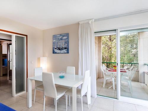 a dining room with a white table and chairs at Apartment Mediterrani by Interhome in Llança