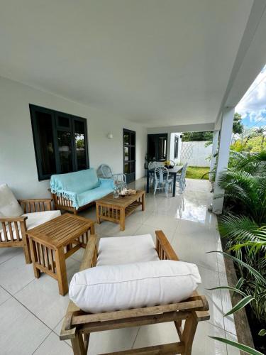 a living room with couches and tables on a patio at Beautiful beach apartment in Flic-en-Flac