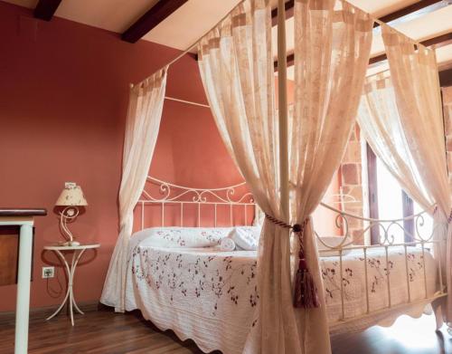 a bedroom with a canopy bed and a window at Peña Caballera in Cardeñosa