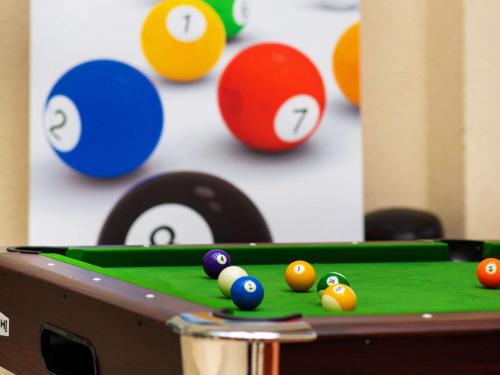 a pool table with billiard balls in front of a wall at Mercure Opole in Opole