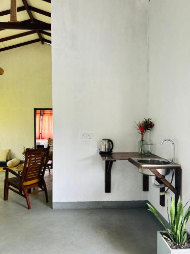 a kitchen with a sink and a table on a wall at One Bhakthi in Ahangama