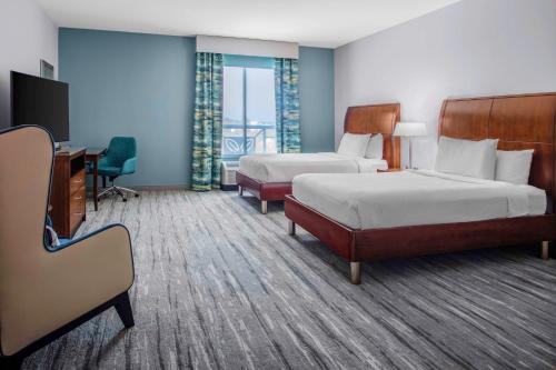 a hotel room with two beds and a desk at Hilton Garden Inn Charleston / Mt. Pleasant in Charleston