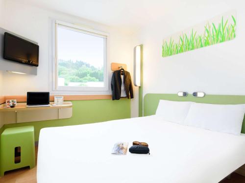 ein Schlafzimmer mit einem weißen Bett und einem Fenster in der Unterkunft Ibis Budget Bilbao Arrigorriaga in Arrigorriaga