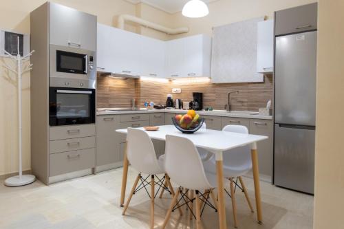 a kitchen with a white table and white chairs at Luxury Apartment in Garitsa Bay in Corfu
