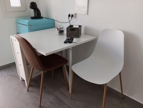 a white desk with two chairs and a blue suitcase at Gaviotas Beach Golf in Almerimar