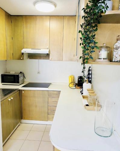 une cuisine avec des armoires en bois et un comptoir blanc dans l'établissement Square central, à Juan-les-Pins