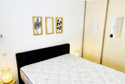 - une chambre avec un lit et trois photos sur le mur dans l'établissement Square central, à Juan-les-Pins