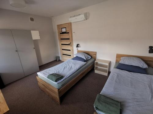 a bedroom with two twin beds and a closet at Bemma Apart Hostel in Wrocław