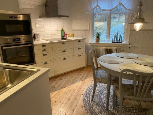 a kitchen with a table with chairs and a sink at Kyrkvik Lysekil in Lysekil
