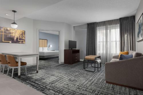 ein Hotelzimmer mit einem Sofa, einem Tisch und einem Bett in der Unterkunft Homewood Suites by Hilton Reading-Wyomissing in Wyomissing