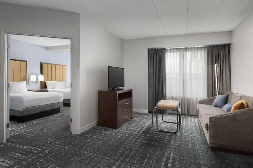 a hotel room with a couch and a tv at Homewood Suites by Hilton Reading-Wyomissing in Wyomissing
