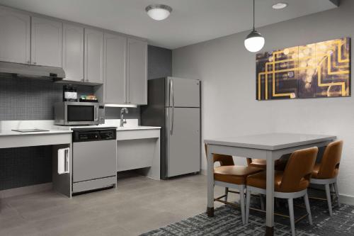 a kitchen with a table and a refrigerator at Homewood Suites by Hilton Reading-Wyomissing in Wyomissing