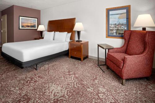 a hotel room with a bed and a chair at Hilton Garden Inn Milford in Milford