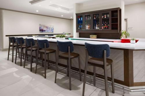 a kitchen with a bar with blue stools at Hilton Garden Inn Milford in Milford
