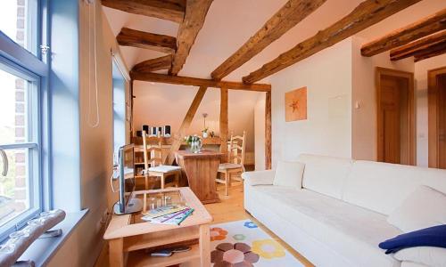 a living room with a white couch and a table at Haus zu den Büschen 04 in Wustrow