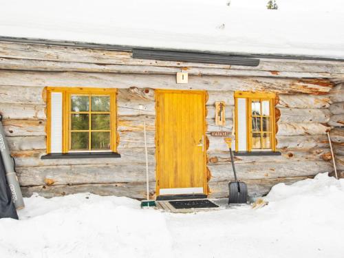 una porta di una baita di tronchi nella neve di Holiday Home Luostonsokka 1 by Interhome a Luosto