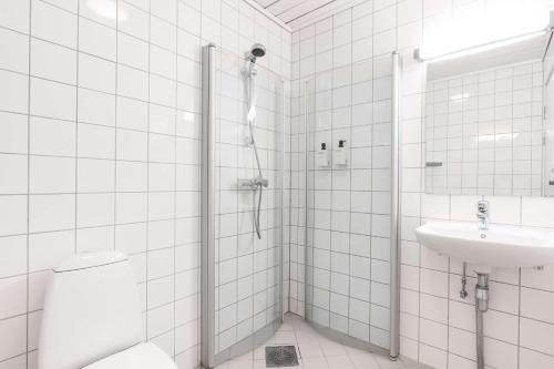 a bathroom with a shower and a toilet and a sink at Olympiatoppen Sportshotel - Scandic Partner in Oslo