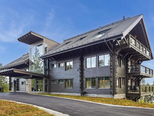 a large wooden house with a balcony on a road at Holiday Home Naava chalet 103 by Interhome in Ähtäri