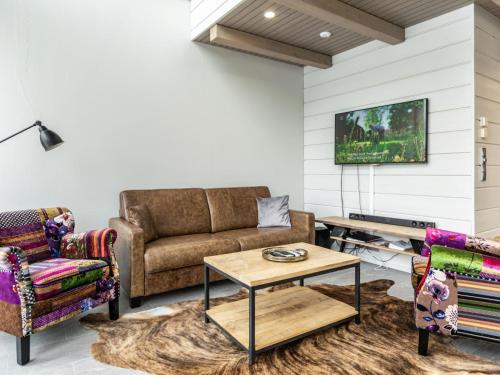 a living room with a couch and a table at Holiday Home Naava chalet 103 by Interhome in Ähtäri