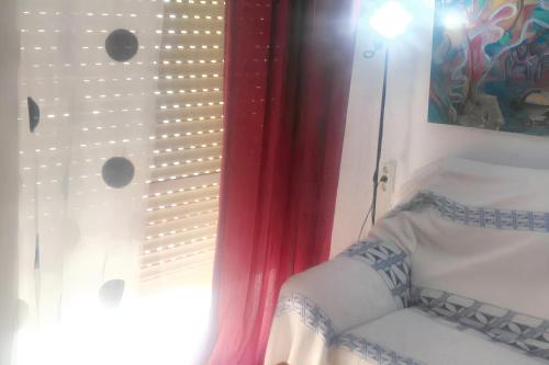 um quarto com uma janela com uma cortina e uma cadeira em Studio with wifi at Torremolinos 1 km away from the beach em Torremolinos