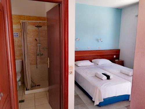 1 dormitorio con cama y ducha en Iris Studios, en Karpathos