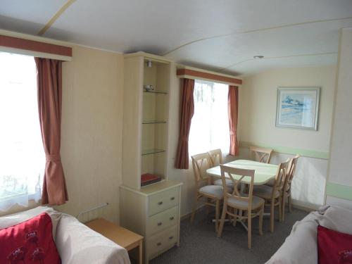 una habitación con mesa y sillas y un dormitorio en Sapphire 8 Berth panel heated Towervans, en Sutton-on-Sea