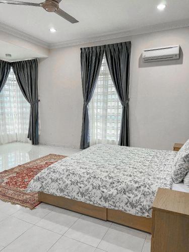 a bedroom with a large bed and two windows at Cahaya Melissa Homestay Private Pool in Melaka
