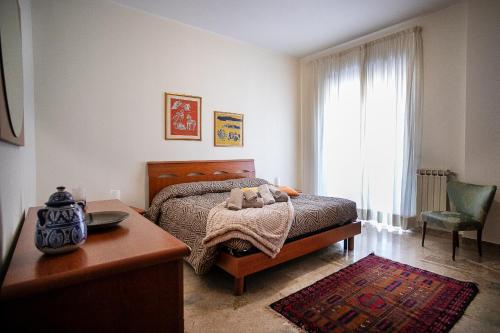 a bedroom with a bed and a table and a window at Monte camicia - cozy home city center in LʼAquila