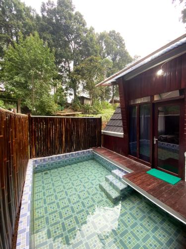 a swimming pool in front of a house at Penginapan segitiga pangalengan in Riunggunung