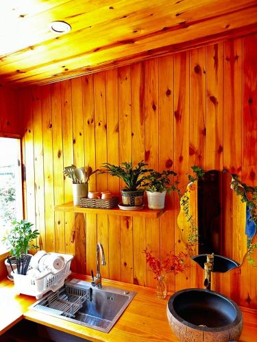 una cucina con lavandino e parete in legno di Lam Vien Garden Villa - Homestay Da Lat a Da Lat