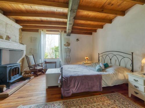 une chambre avec un lit et une cheminée dans l'établissement Holiday Home Ecossais du Bourg by Interhome, à Rioux-Martin