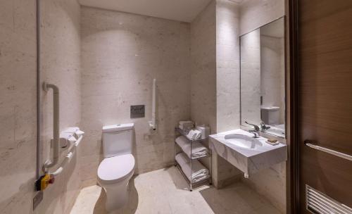 y baño con aseo y lavamanos. en Hilton Garden Inn Hong Kong Mongkok, en Hong Kong