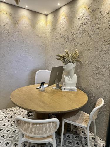 a table with a vase with a laptop on it at Aldara Sitges in Sitges