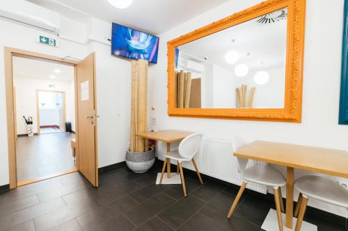 a dining room with a table and a mirror at Hostel Mandarinka in Prague