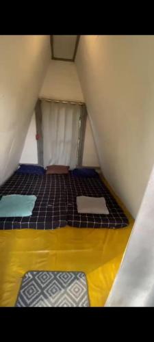 a small room with two beds in a attic at Penginapan segitiga pangalengan in Riunggunung