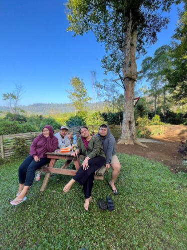 a group of people sitting on a picnic table at Penginapan segitiga pangalengan in Riunggunung