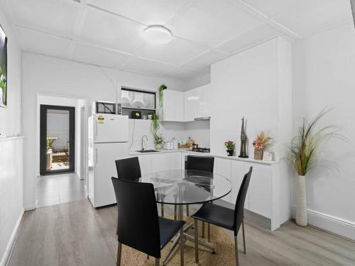 a kitchen with a glass table and black chairs at Central 3BR & Central station&Chinatown-5 mins walk in Sydney