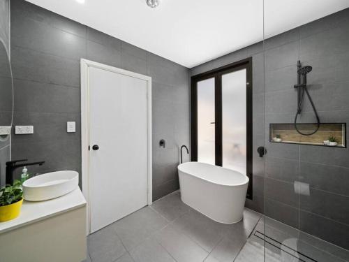 a bathroom with a white tub and a sink at Central 3BR & Central station&Chinatown-5 mins walk in Sydney