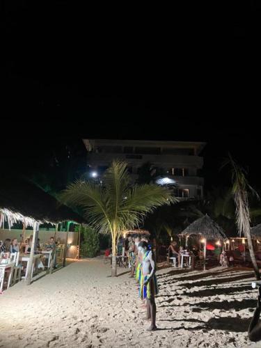 a man standing on a beach at night at SunSeaBar Beach Resort in Kendwa
