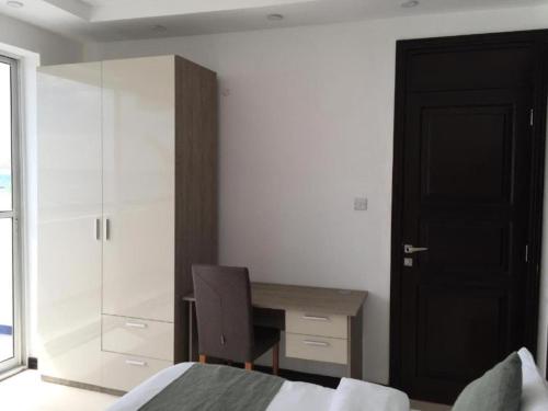 a bedroom with a desk and a bed and a chair at SunSeaBar Beach Resort in Kendwa
