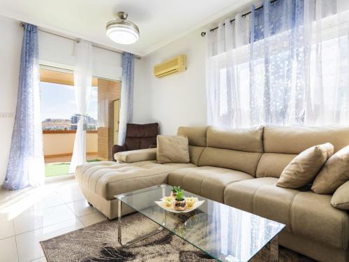 een woonkamer met een bank en een glazen tafel bij Apartment Vistamar II - Marina d'Or by Interhome in Oropesa del Mar