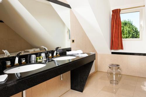 a bathroom with two sinks and a window at Logis L'Auberge - Maison Glenn Anna in Sainte Anne d'Auray