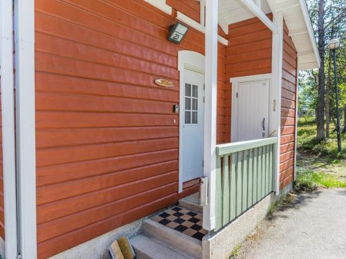 Una puerta de entrada de una casa roja con un porche a cuadros. en Holiday Home Moitakuru a23 by Interhome, en Saariselkä