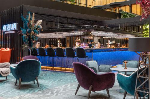 un bar junto a la piscina con sillas y mesas en un edificio en Radisson Blu Scandinavia Hotel, Göteborg, en Gotemburgo