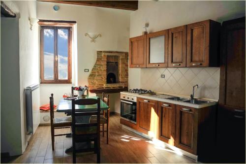 eine Küche mit Holzschränken, einem Tisch und einem Herd in der Unterkunft Il Palazzo del Barone - Dimora storica in Pietrapertosa