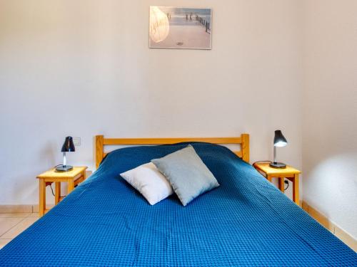 a blue bed with two pillows on top of it at Holiday Home Les hameaux de l'Océan by Interhome in Maubuisson
