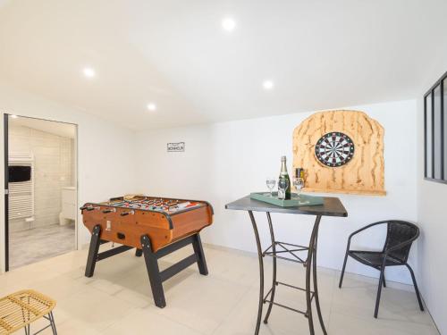 une salle à manger avec une table et une table de jeu dans l'établissement Villa Charme de la Blancharderie by Interhome, à Barbâtre