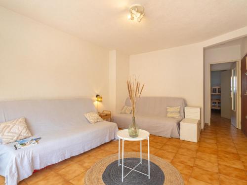 Cette chambre comprend 2 lits et un vase sur une table. dans l'établissement Apartment Helios by Interhome, à Six-Fours-les-Plages