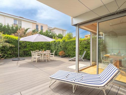 un patio avec une table, des chaises et un parasol dans l'établissement Apartment Helios by Interhome, à Six-Fours-les-Plages