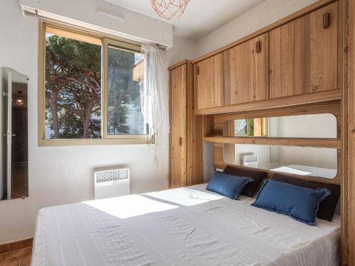 une chambre avec un grand lit avec des oreillers bleus dans l'établissement Apartment Les Regates-6 by Interhome, à Hyères